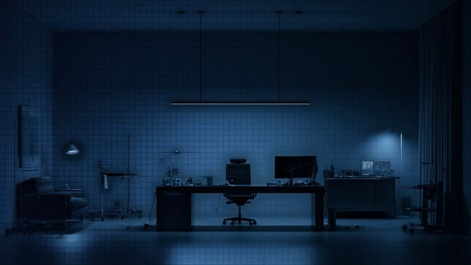 An empty medical office at night, the reading monitor dark on the desk