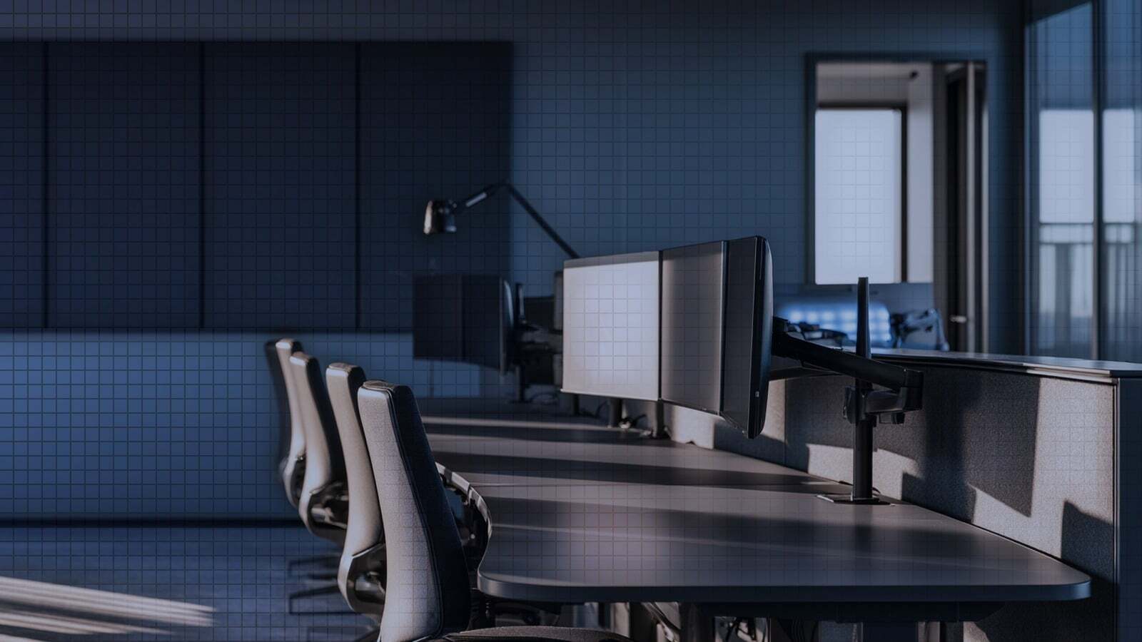 An empty radiology reading room: a curved row of unoccupied workstations with blank monitors and vacant chairs.